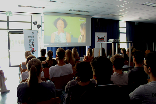 Alt:'Grafik: Foto von Schüler:innen im Rahmen des 'Demokratie für Alle' Workshops von SOS Mitmensch an der Schule ORG/RG Anton-Krieger-Gasse.