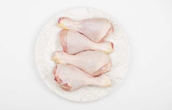 Top view of pile of raw chicken thighs isolated on dish.