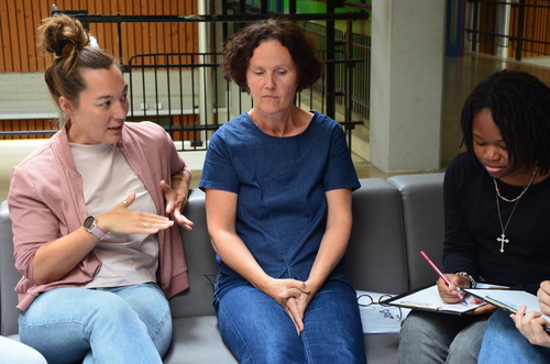 Alt:'Grafik: Foto von Schüler:innen im Interview mit SOS Mitmensch Mitarbeiter:innen im Rahmen des 'Demokratie für Alle' Workshops von SOS Mitmensch an der Schule ORG/RG Anton-Krieger-Gasse.